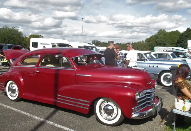 A red 1940s fastback with whitewall tyres