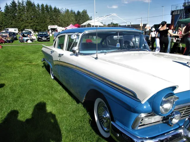 A blue and white 1950s Ford from the side